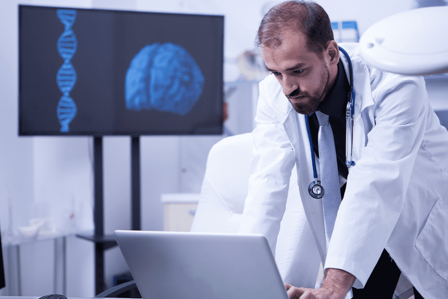 A physician consults his laptop during deep brain stimulation