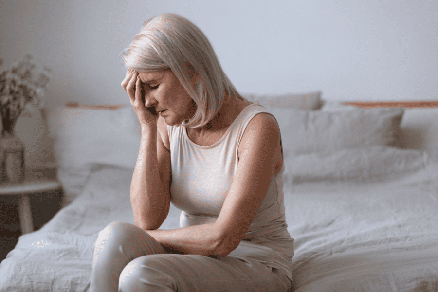 senior woman holding head in pain from headache