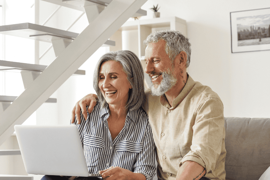 Senior couple at home using laptop