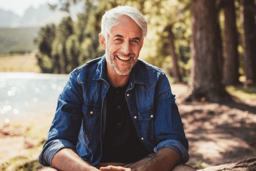 man sitting by lake enjoying the weather