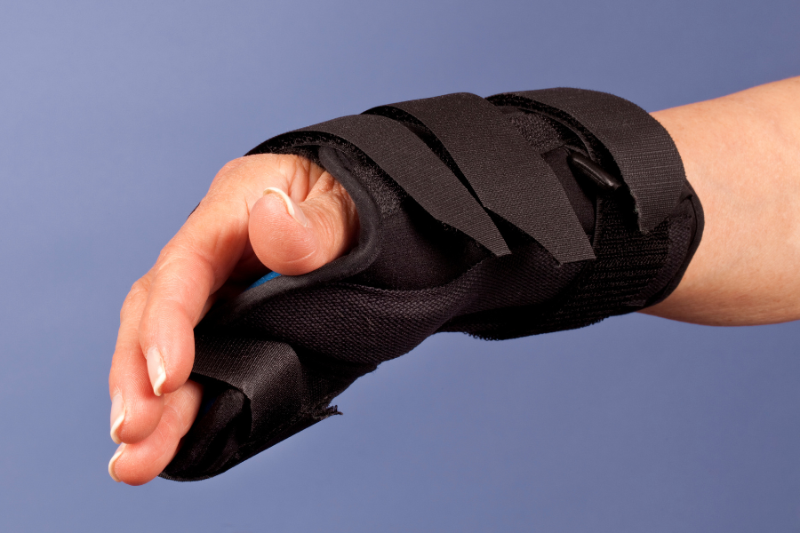 Close-up of a hand wearing a supportive brace for injury or strain.